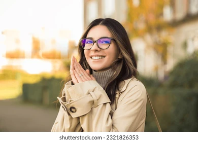 Mujer joven de piel blanca y cabello moreno con leves iluminaciones rubias. Se muestra sonriente.